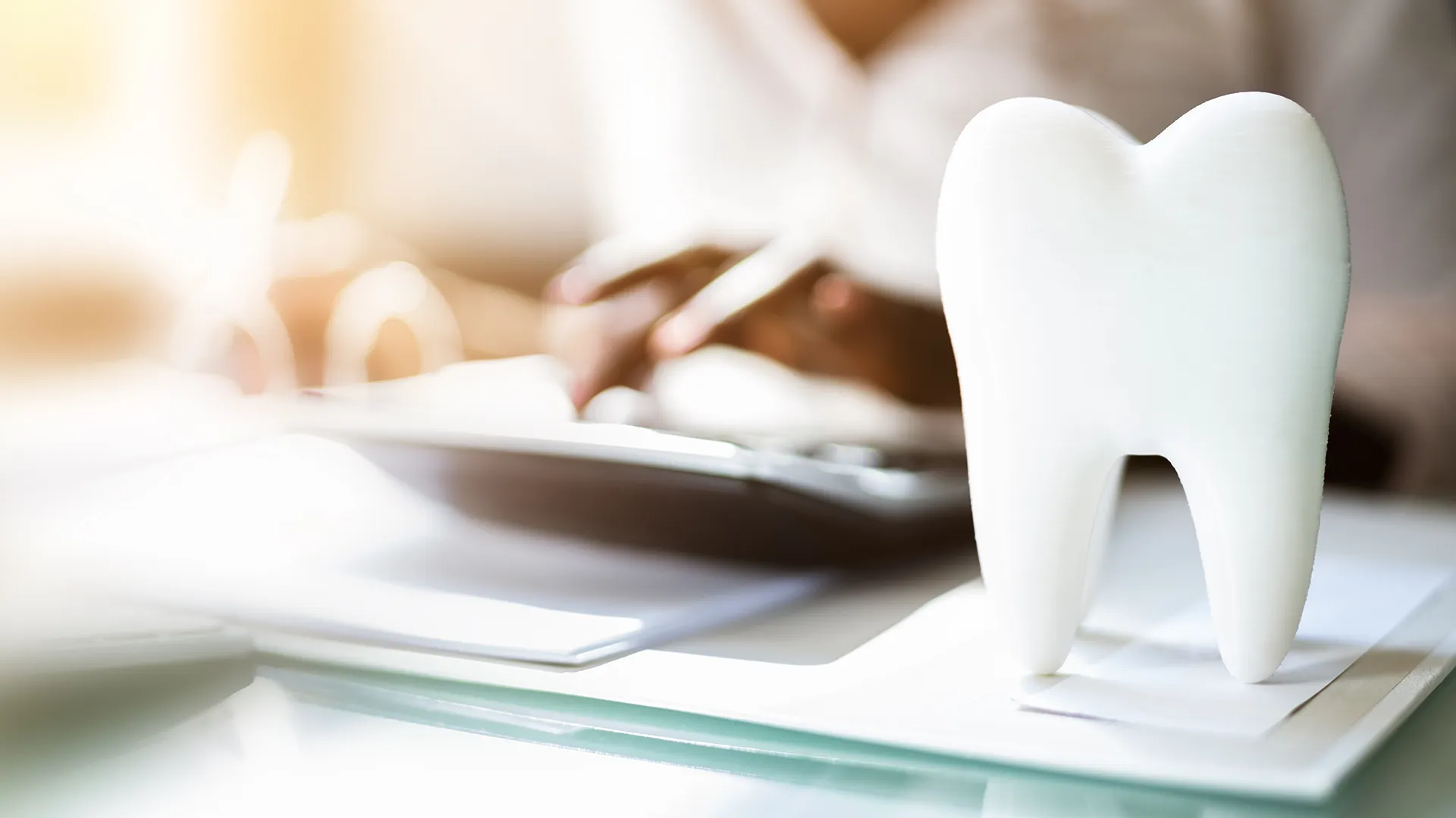 Artificial tooth standing upright on a dentist's desk.