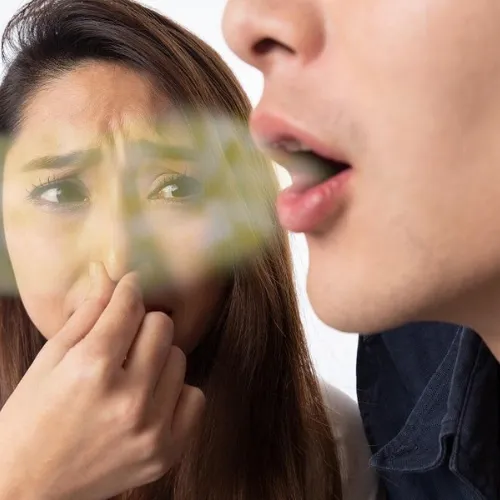 Woman holding her nose beside man with fogged breath coming out of his mouth.