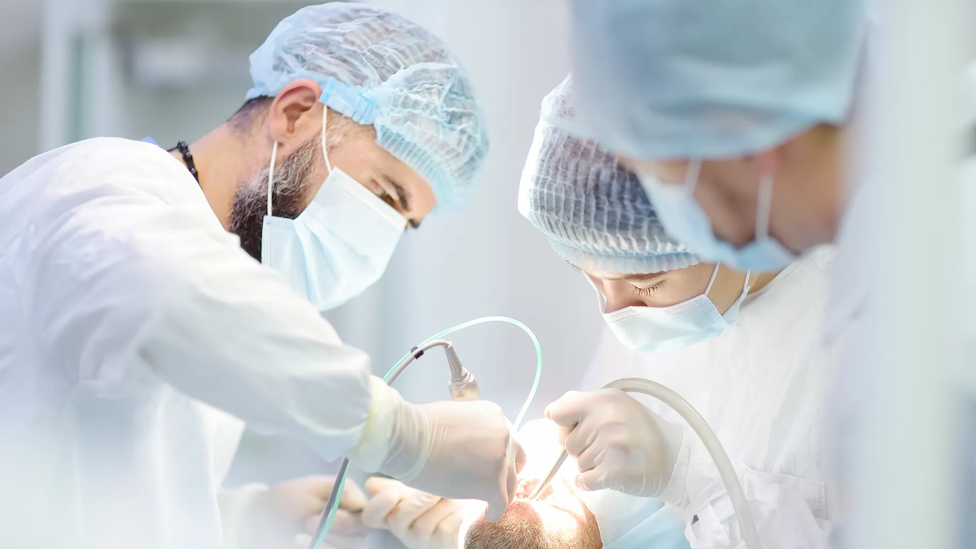 Group of oral surgeons performing a procedure on a patient.