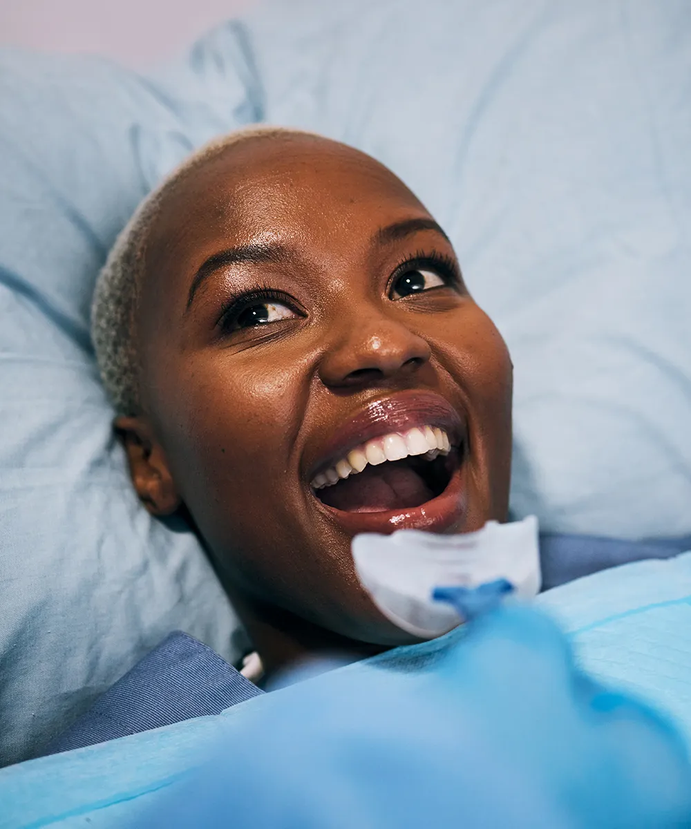 Woman lying on a dental chair, smiling.
