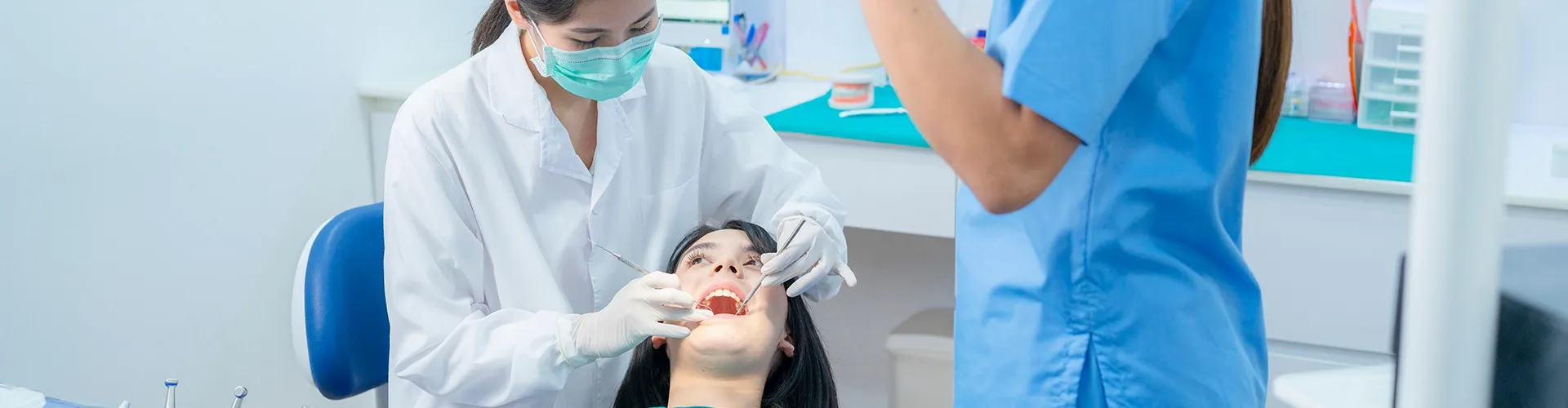dental team using dental tools in patient's mouth
