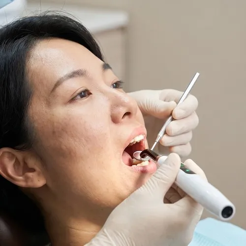 Dentist using dental tools to examine a patient.