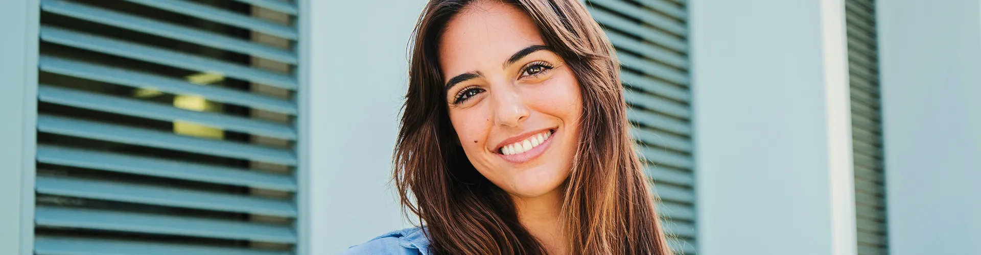 Smiling woman with brown hair in blue shirt.