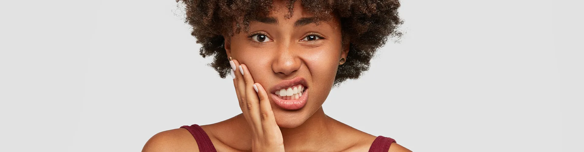 Woman holding her cheek in pain.