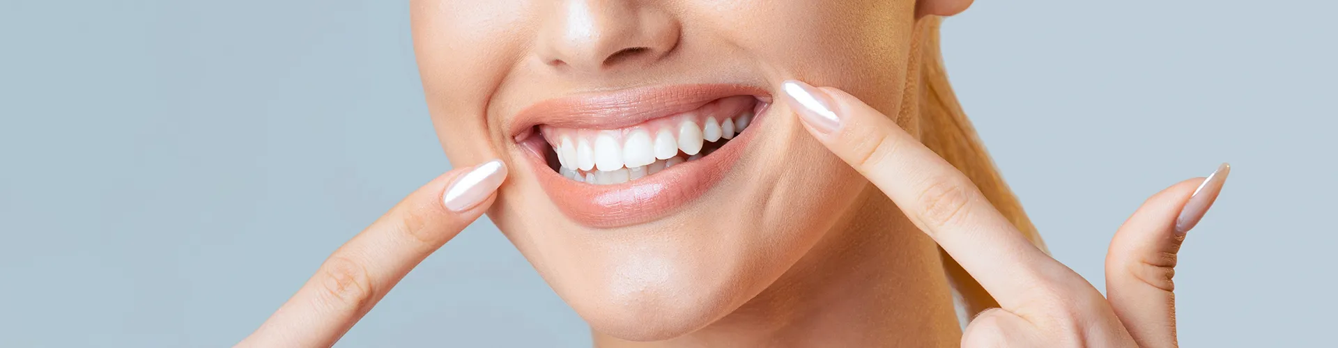 woman pointing at her smile with both index fingers