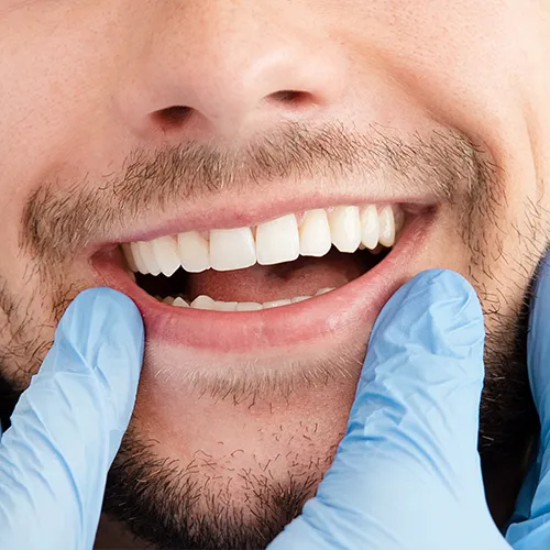 gloved fingers framing man's smile