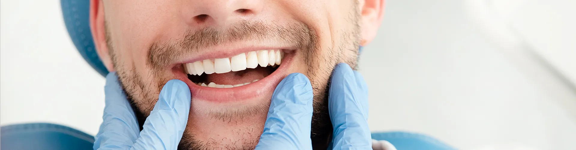 gloved fingers framing man's smile