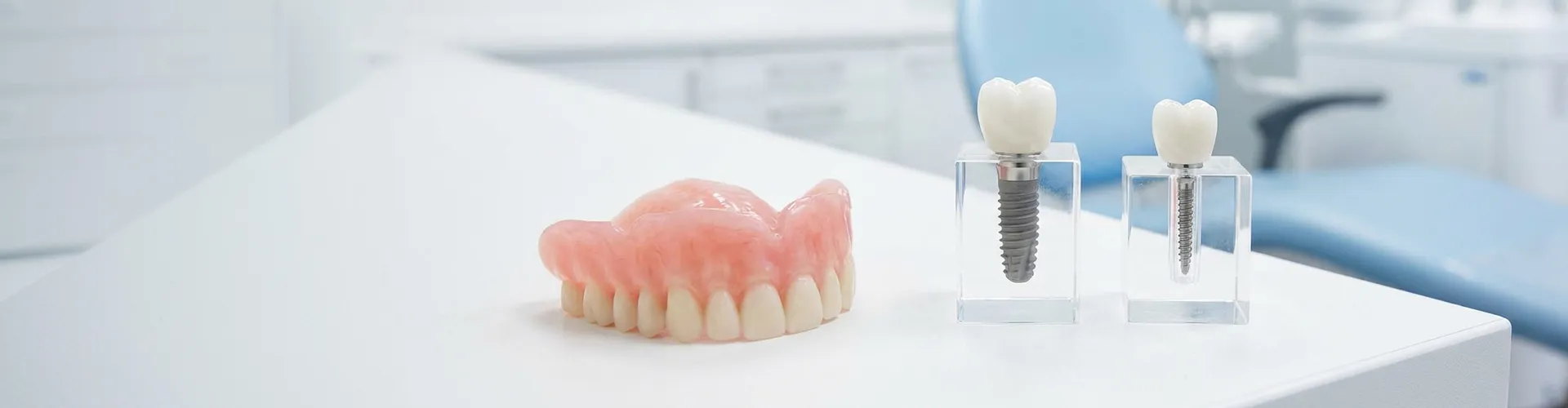 Dental implant beside mini dental implant on white surface.