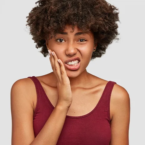 Woman holding her cheek in pain.