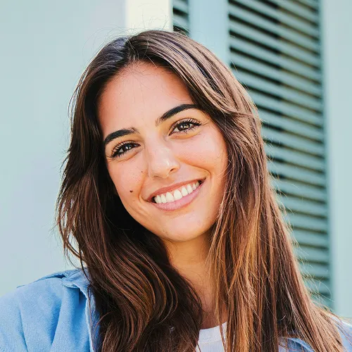 Smiling woman with brown hair in blue shirt.